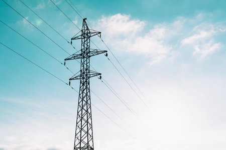 Strommast vor blauem Himmel fotografiert.